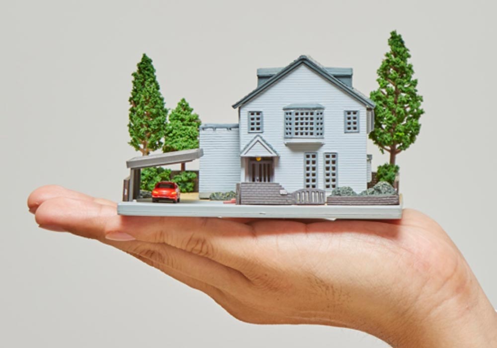 Hand holding model house